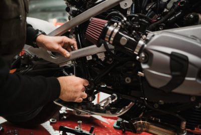 man fixing a motorcycle in a modern workshop
